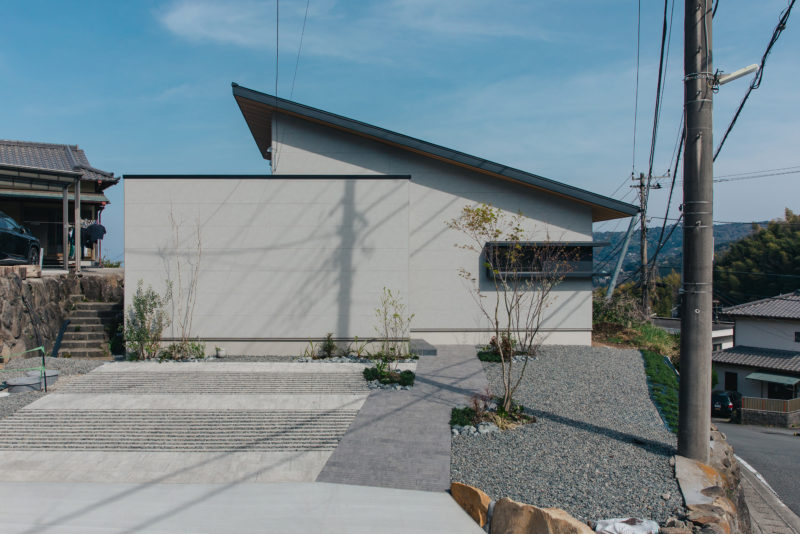 シンプルな片流れの屋根が印象的な植栽が映える外観