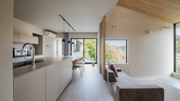 海と山を望む吹抜けリビングのある家