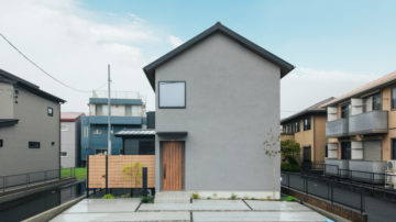 グレーの塗壁とガルバの三角屋根の家