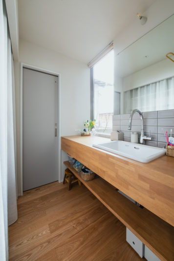 植栽を望むピクチャーウィンドウのある造作洗面