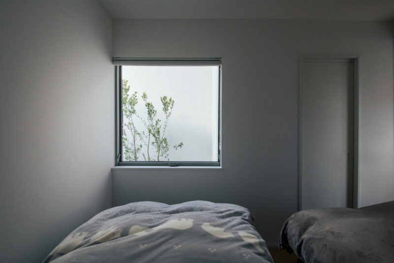 緑を楽しむピクチャーウィンドウのある寝室