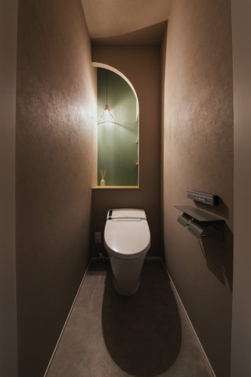 アーチの壁と照明が可愛いトイレ
